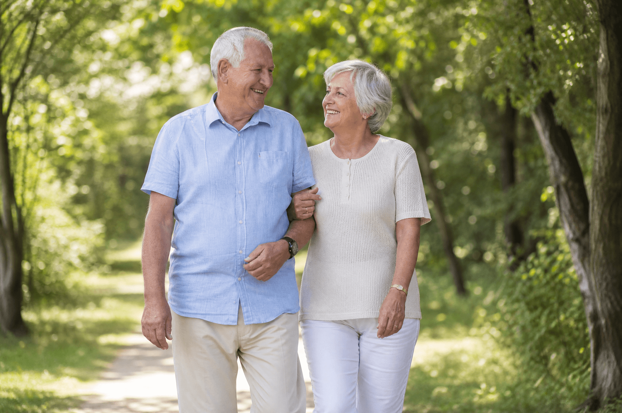 A couple walking confidently together along a tree-lined path